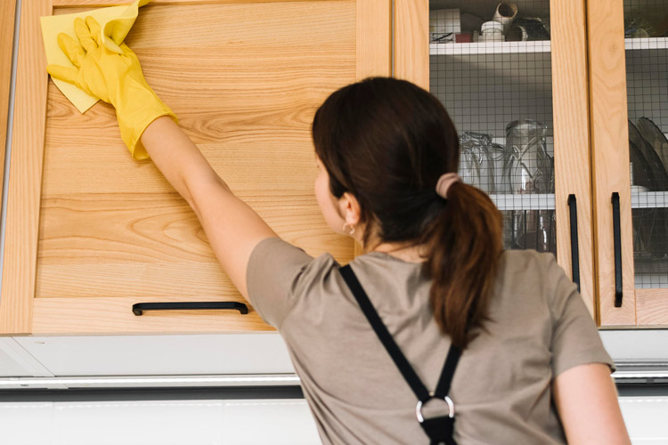 A cleaner wiping down cabinets
