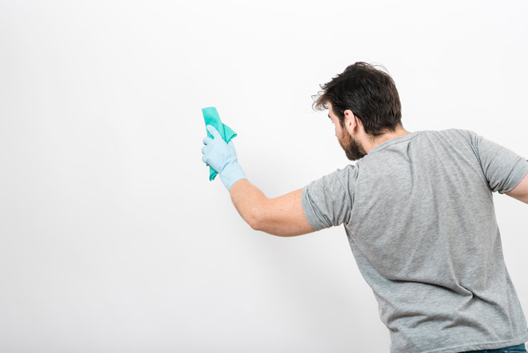 Man wiping down walls