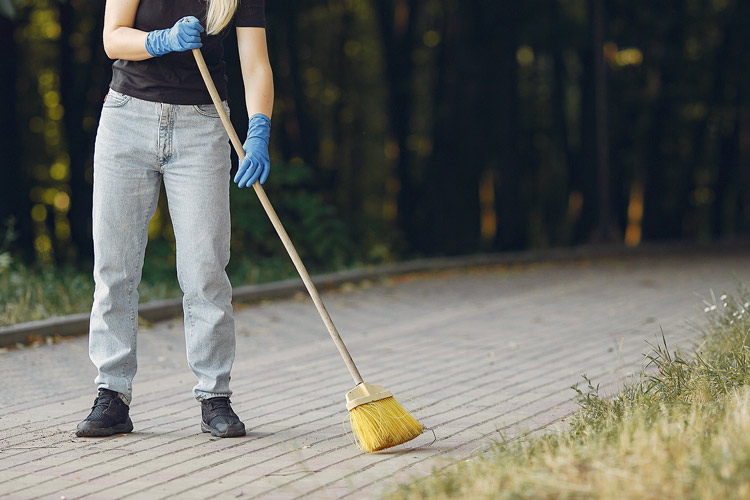 Woman sweeping outside