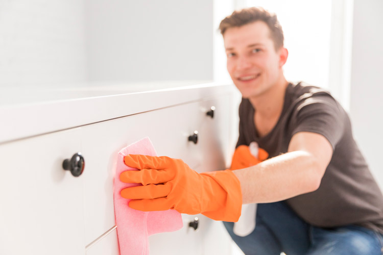 Guy with orange rubber gloves cleaning drawers