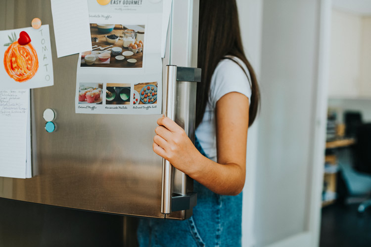 Girl opening up refrigerator
