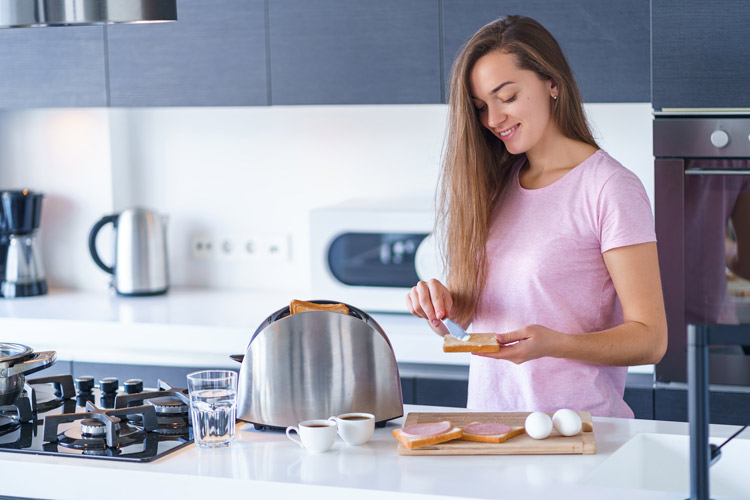 Woman in pink shirt buttering toast
