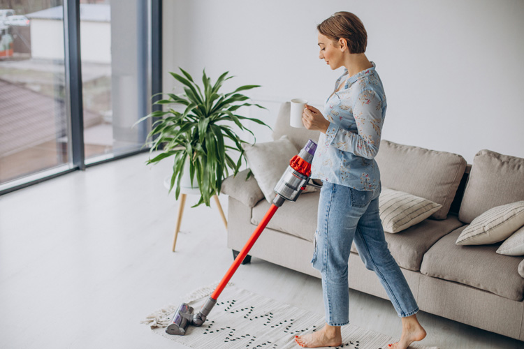 Woman vacuuming living room.