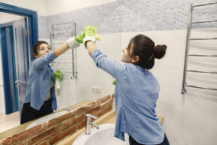 Women Cleaning Mirror