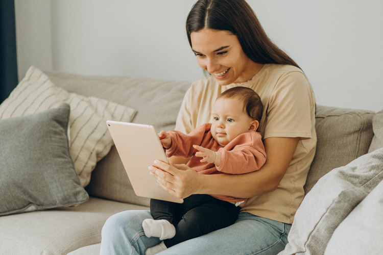 Woman holding baby and iPad