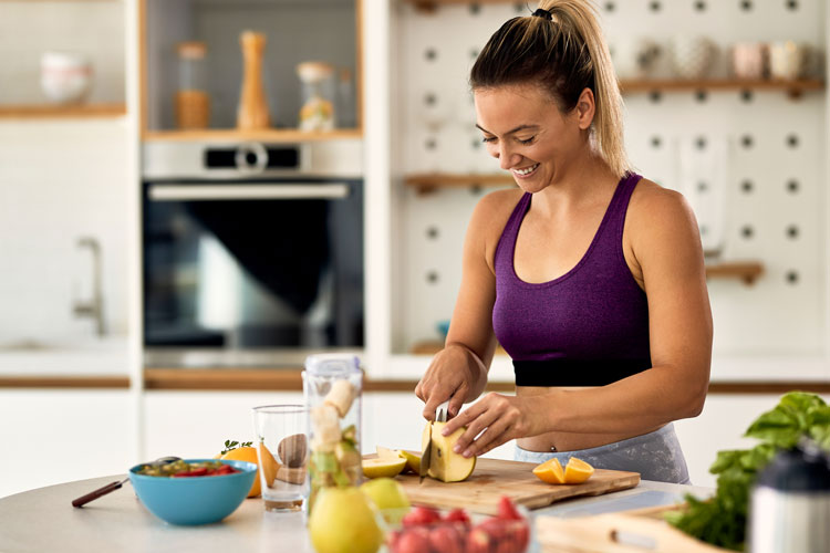 A healthy woman cutting up fruit